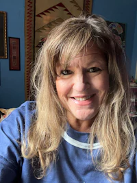 a woman in a blue shirt smiling at the camera